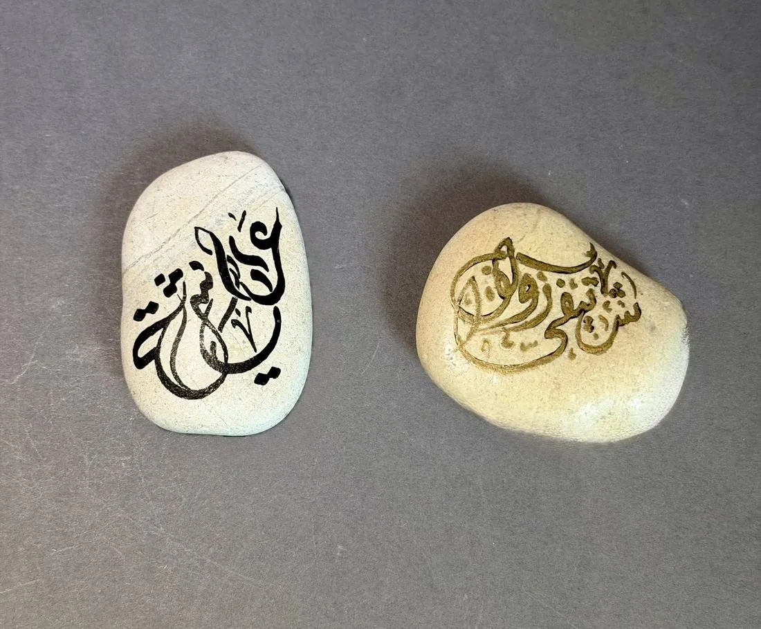 Zwei Kieselsteine mit handbemalter Kalligrafie